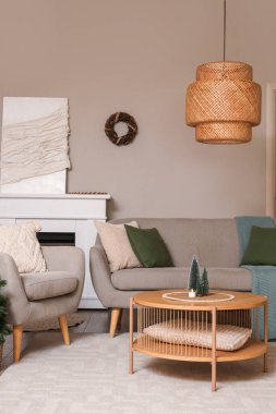 Noel çelengi, kanepe ve masa oturma odasının iç tarafındaki dekoratif ağaçlarla dolu.