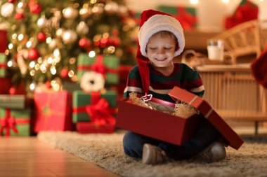 Noel Baba şapkalı şirin bir çocuk Noel arifesinde evde oturuyor.