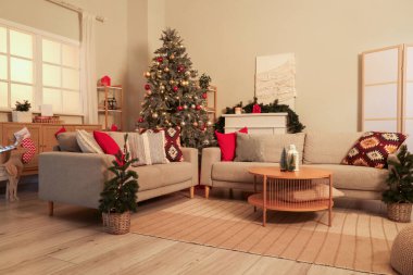 Gri kanepe, Noel ağacı ve akşam süsleriyle oturma odasının içinde.
