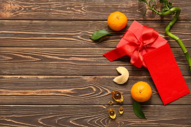 Mandalinalı zarf, hediye kutusu, bambu sapı ve kahverengi ahşap arka planda Çin sembolleri. Yeni yıl kutlaması