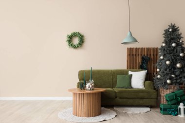 İçinde yeşil kanepe, Noel ağacı ve hediye kutuları olan oturma odası.