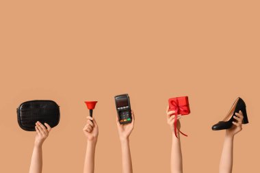 Aksesuarları, ödeme terminali ve bej arka planda Noel hediye kutusu olan birçok kadın eli.