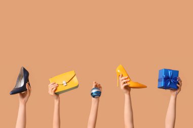 Aksesuarları, Noel balosu ve bej arka planda hediye kutusu olan birçok kadın eli.