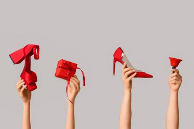 Ayakkabılı birçok kadın eli, Noel hediyesi kutusu ve gri arka planda zil.