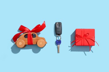Hediye kutusu, yeni arabanın anahtarları ve arka planda tahta oyuncak.