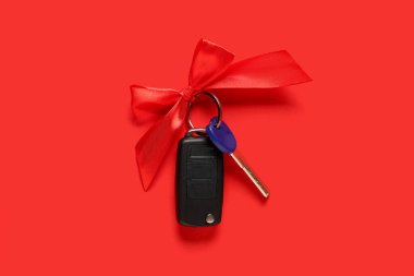 Kırmızı arka planı olan yeni arabanın hediye anahtarları.