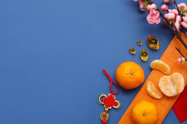 Mavi arka planda Çince ve sakura sembolleri olan Mandarinler. Yeni yıl kutlaması