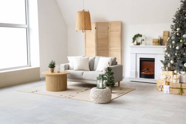 Interior of modern living room with fireplace decorated for Christmas