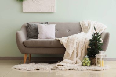 Oturma odasında feneri ve kanepesi olan Noel ağacı.