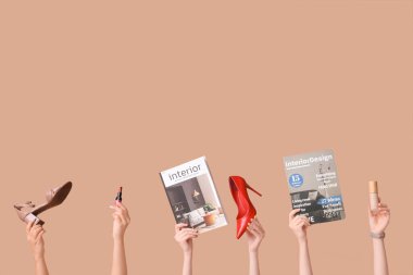 Farklı dergilere sahip kadın elleri, yüksek topuklar, kahverengi arka planda ruj ve makyaj temeli