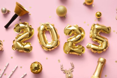 2025 yılbaşı topları, zili ve pembe arka planda bir şişe şampanyası olan folyodan yapılmış.
