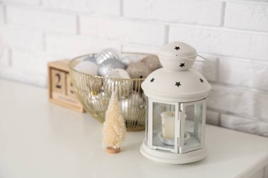 Noel süslemeleri, mini köknar ağacı, beyaz tuğla duvarın yanındaki çekmecelerin üzerindeki fener. Yakın çekim.