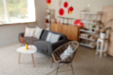 Japon Yeni Yıl kutlamaları için kanepe, raf üniteleri ve dekorla oturma odasının bulanık görüntüsü