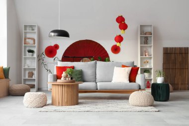 Japon Yeni Yıl kutlamaları için kanepe, puf ve dekorla oturma odasının içinde.