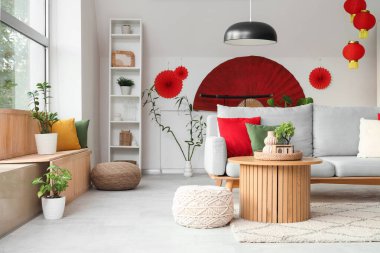 Japon Yeni Yıl kutlamaları için kanepe, masa ve dekorla aydınlık oturma odasının içinde.