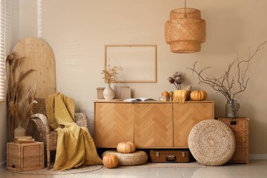 Örgülü koltuk, balkabağı, ekose, kanepe ve çekmeceler sonbahar salonunda.