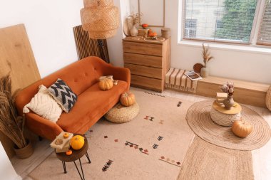 Rahat kanepe, balkabağı, sehpa ve çekmeceler sonbaharda oturma odasının iç kısmında.