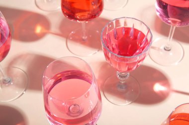 Bej arka planda lezzetli pembe şarap kadehleri