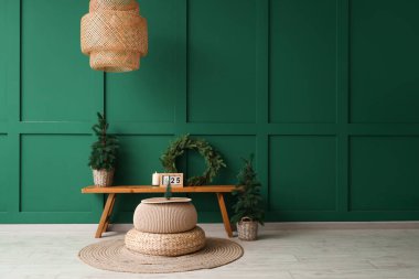 Odanın içinde Noel ağaçları, çelenkler ve ahşap banklar var.