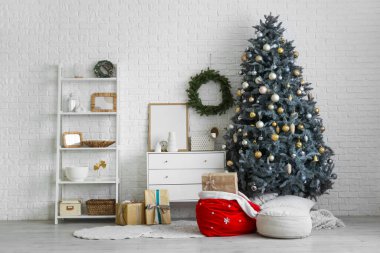 Oturma odasının içinde Noel ağacı, çekmece ve Noel Baba çantası var.