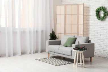 Kanepesi, perdesi ve Noel ağacı olan modern oturma odasının içinde.