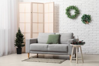 Kanepesi, perdesi ve Noel ağacı olan modern oturma odasının içinde.