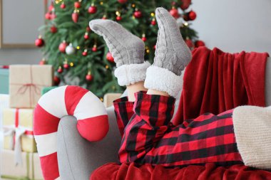 Sıcak çoraplı bir kadın Noel arifesinde evde uzanıyor, yakın plan.