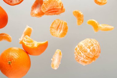 Gri arka planda tatlı olgun mandalinalar uçuyor