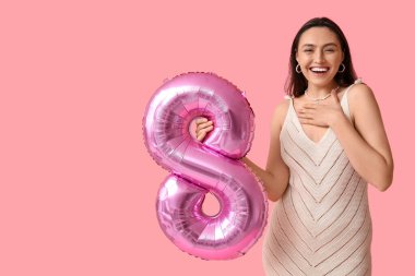 Renkli arka planda, şekil 8 şeklinde pembe hava balonu olan mutlu genç bir kadın. Uluslararası Kadınlar Günü