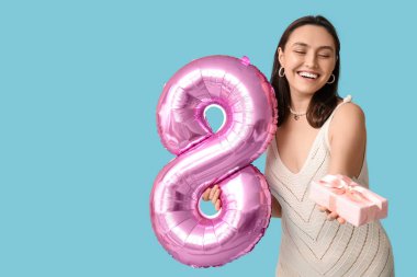Pembe balonlu mutlu genç bir kadın. Şekil 8 ve mavi arka planda hediye kutusu. Uluslararası Kadınlar Günü