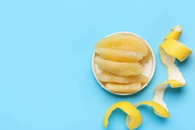 Meyve parçalarıyla kaplı bir tabak ve mavi arka planda kabuk.