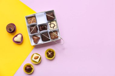 Lezzetli şekerlerle dolu bir kutu ve arka planda mutfak maşası.