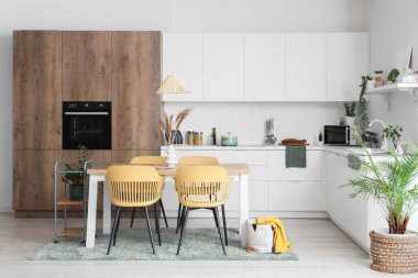 Modern yemek odasının içinde masa ve sandalyeler var.