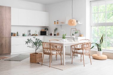 Masa ve hasır sandalyeli hafif yemek odasının içi.