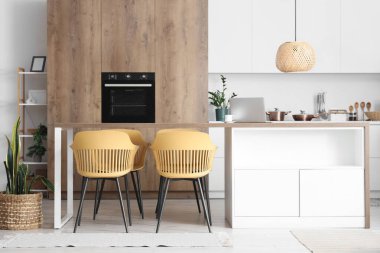 Modern yemek odasının içindeki tahta masa ve sandalyeler.