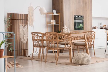 Hasır sandalyeler, masa ve katlanan ekran şık yemek odasının içinde.