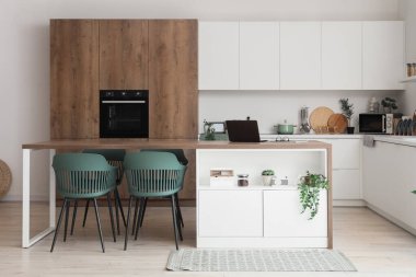 Yemek odasının içinde masa, sandalye ve çekmeceler var.