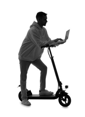 Beyaz arka planda dizüstü bilgisayar kullanan elektrikli scooterlı genç adamın silueti.