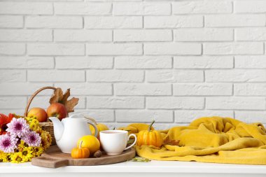 Çay demliği, bir fincan lezzetli yeşil çay, ahşap tepsi, balkabağı, ekose ve ahşap tepsi odada.