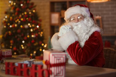 Noel Baba Noel arifesinde evde oturuyor.