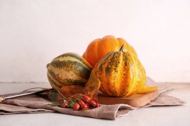 Taze balkabaklı ahşap tahta tahta, beyaz arka planda gül kalçası böğürtlen ve sonbahar yaprakları