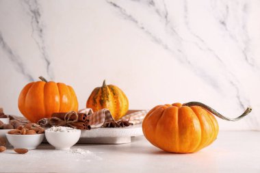 Beyaz arka planda taze balkabağı, tarçın, yıldız anason ve badem fıstıklı pano.