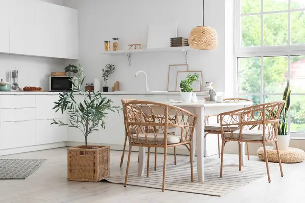 Masa ve hasır sandalyeli hafif yemek odasının içi.