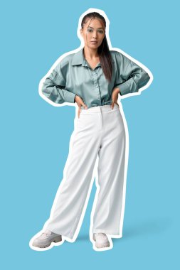 Şık makyajlı ve mavi arka planda giysileri olan güzel Asyalı kadın.