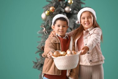 Noel topları ve yeşil arka planda köknar ağacı olan şirin çocuklar.
