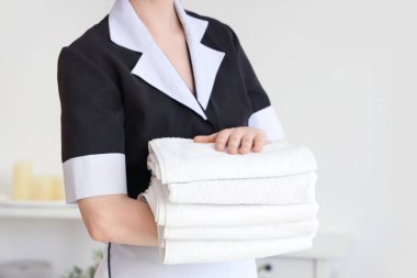 Otel odasında temiz havluları olan oda hizmetçisi.