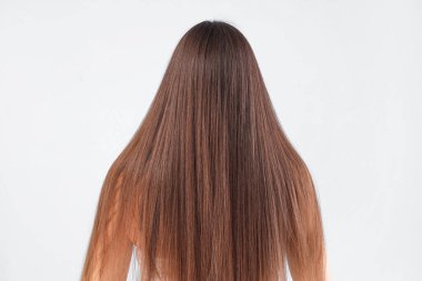 Mavi arka planda güzel saçları olan esmer bir kadın.