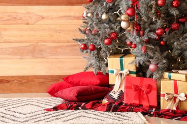 Güzel Noel ağacı, hediye kutuları ve ahşap duvarlara karşı yastıklar