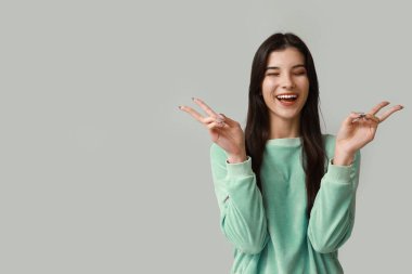 Arka planda barış işareti gösteren genç bir kadın