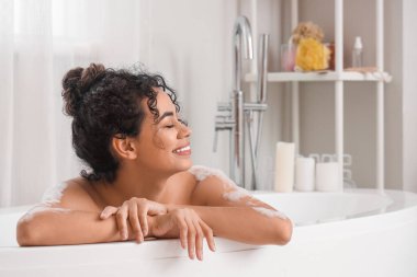 Genç Afro-Amerikalı kadın evde banyo yapıyor.